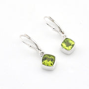 Silver earrings with green gemstones on a white background