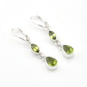 Pair of silver earrings with green gemstones on a white background