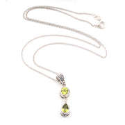 Silver necklace with two green peridot gemstones on a white background