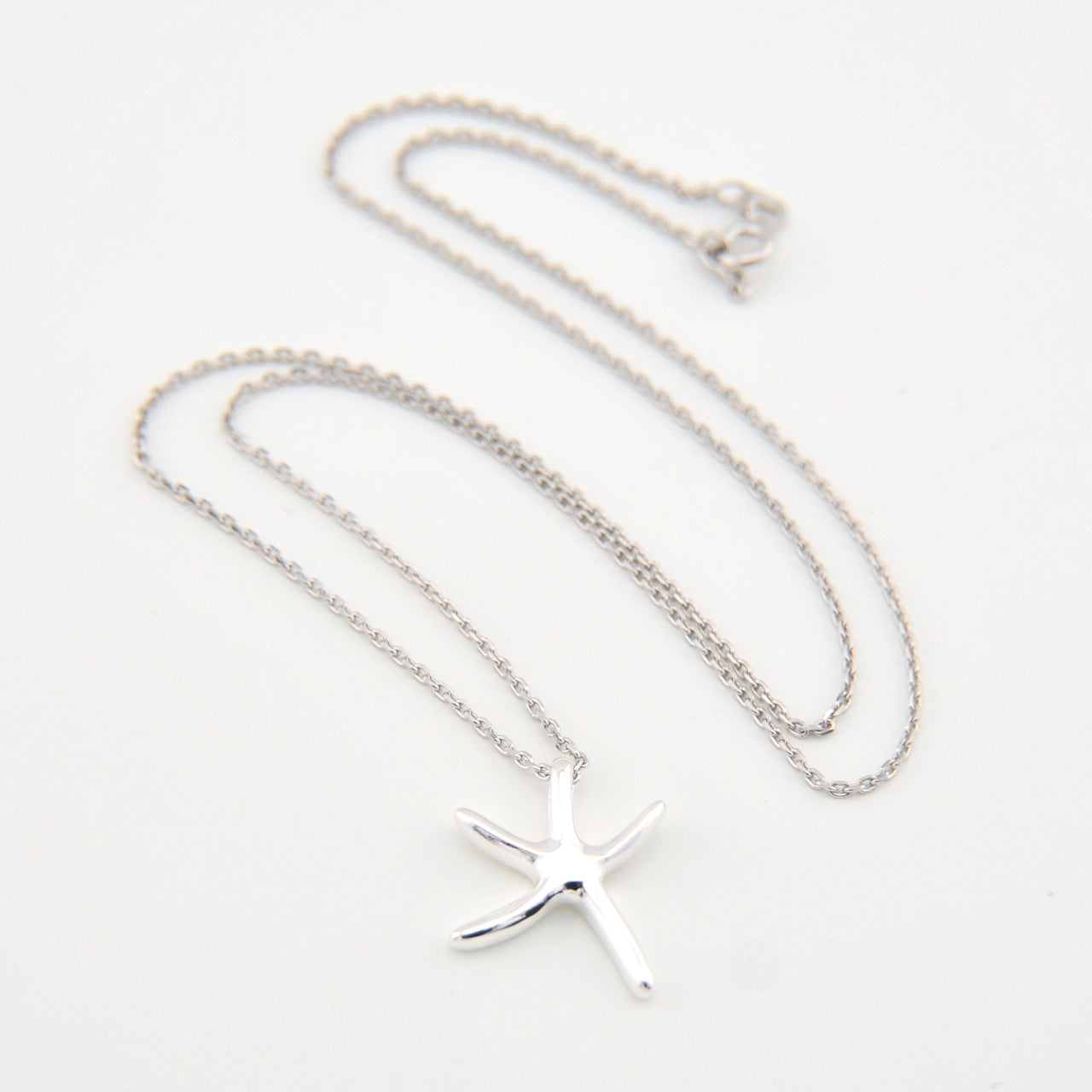 Silver starfish pendant necklace on a white background