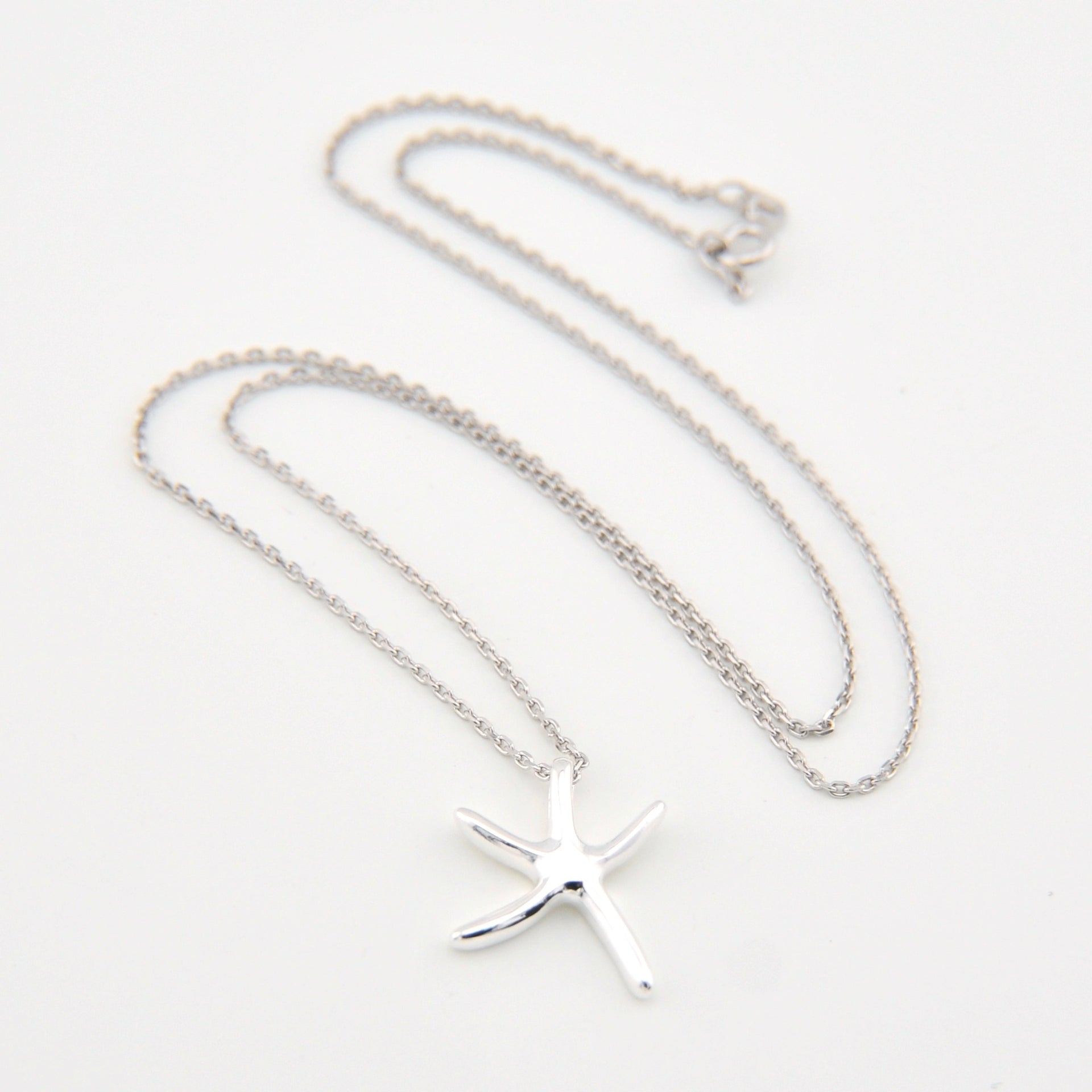 Silver starfish pendant necklace on a white background