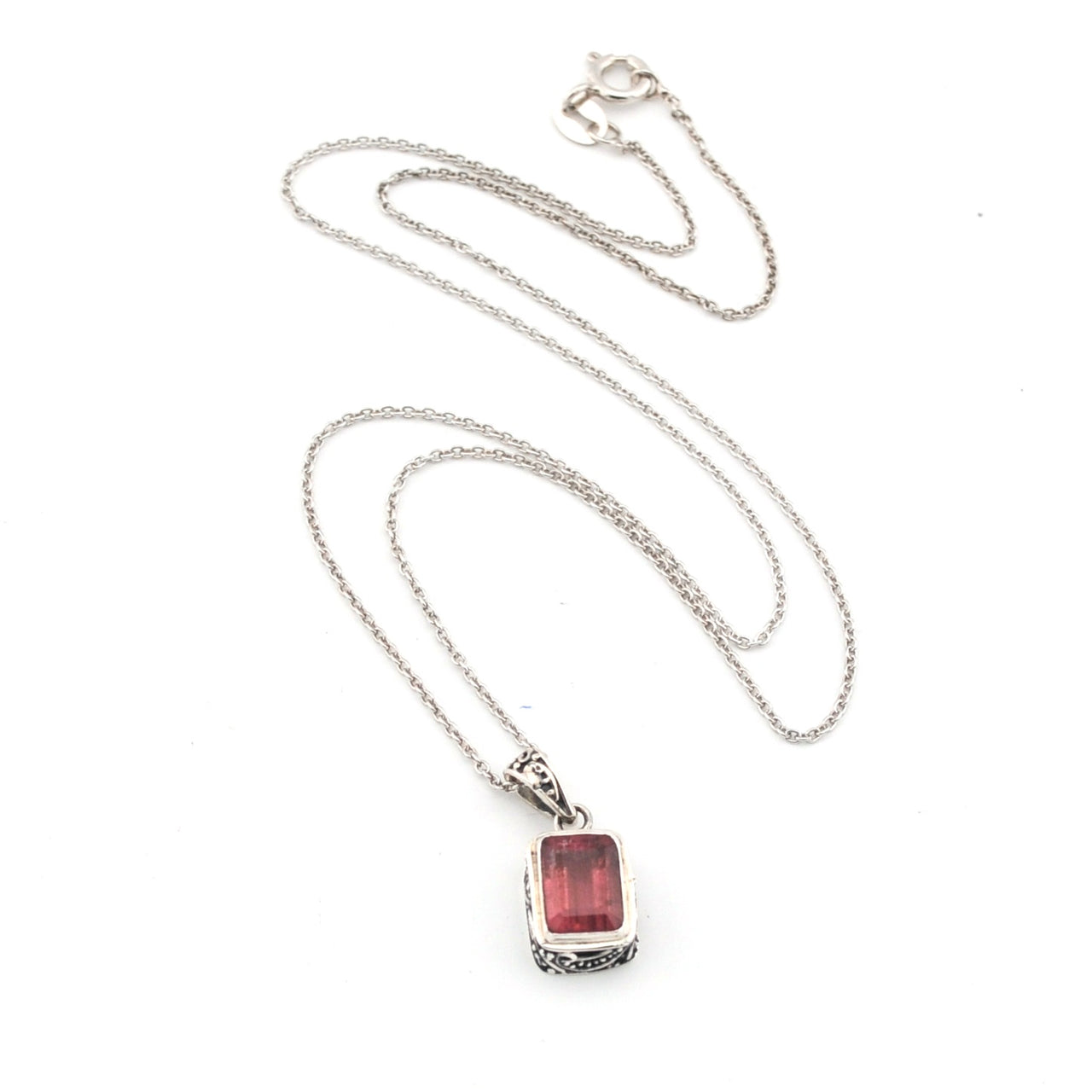 Silver necklace with a red pendant on a white background
