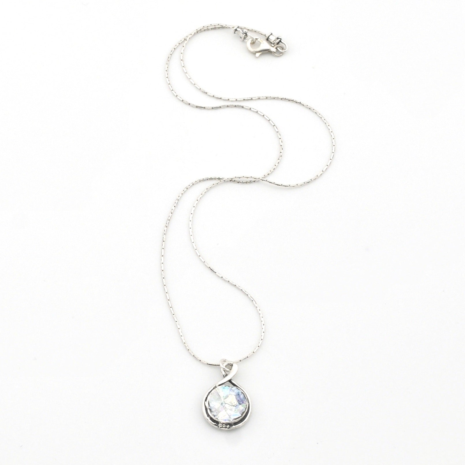 Silver necklace with a teardrop-shaped pendant on a white background