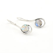 Silver earrings with round gemstones on a white background