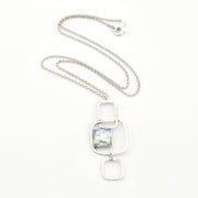 Silver necklace with a rectangular pendant on a white background