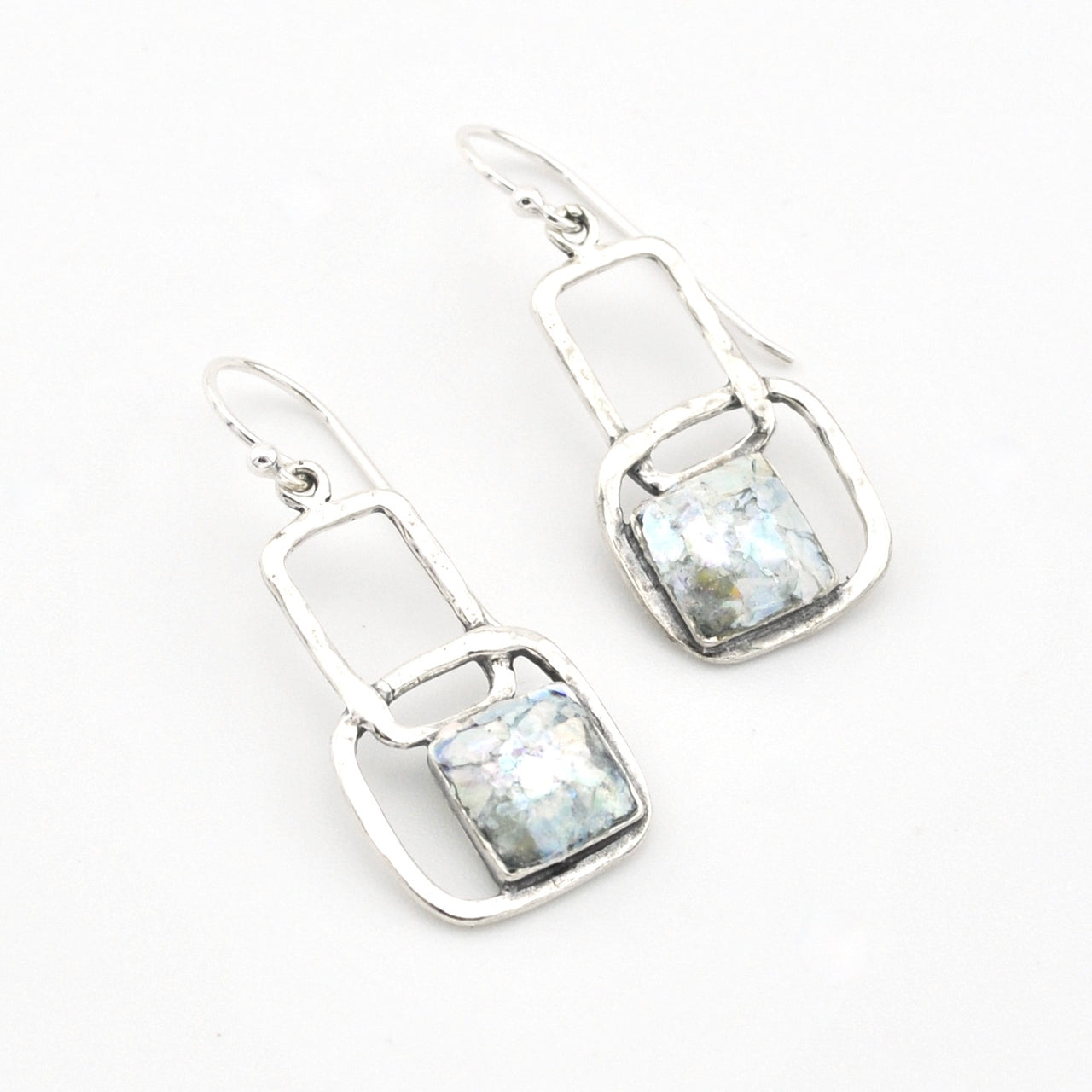 Silver earrings with ancient glass on a white background