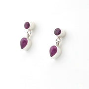 Pair of earrings with purple teardrop-shaped stones on a white background