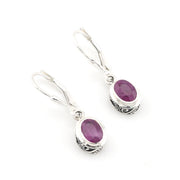 Silver earrings with purple gemstones on a white background