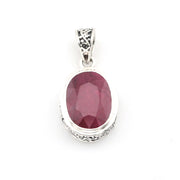 Silver pendant with a red gemstone on a white background