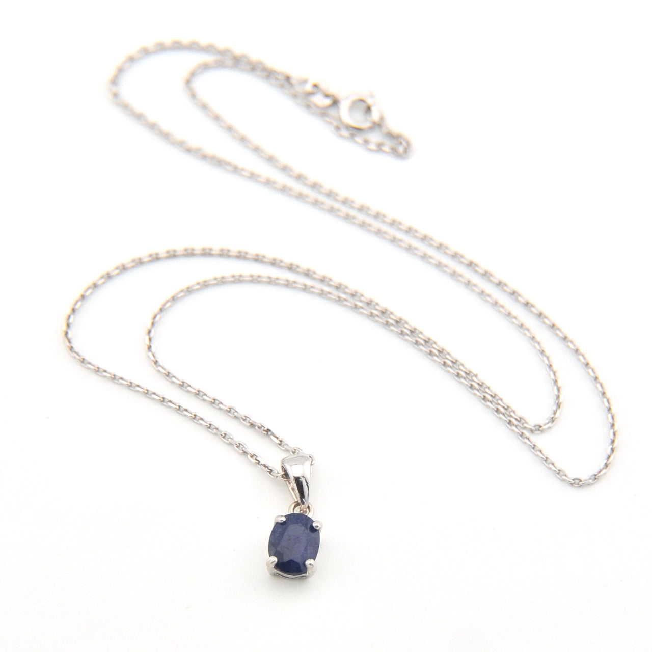 Silver necklace with a blue gemstone pendant on a white background