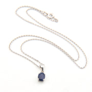 Silver necklace with a blue gemstone pendant on a white background