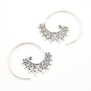 Pair of silver hoop earrings with intricate designs on a white background