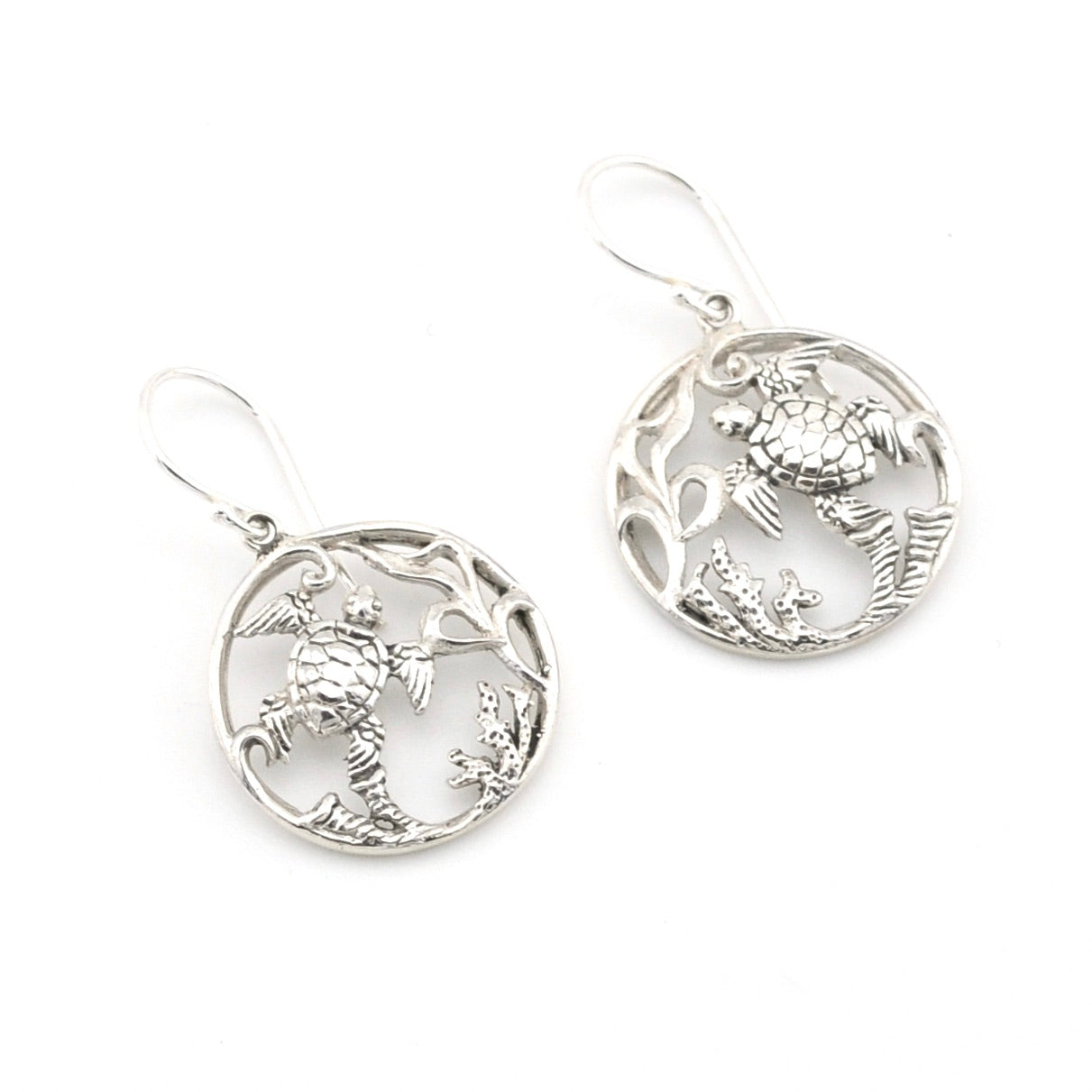 Pair of silver earrings with intricate designs on a white background
