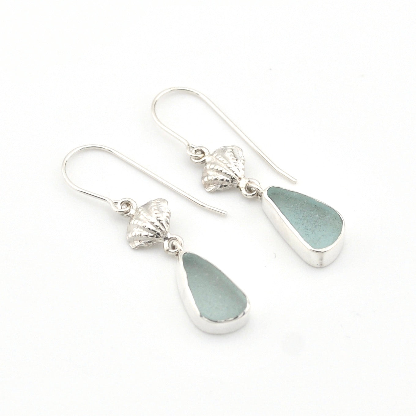 Silver earrings with teardrop-shaped sea glass on a white background
