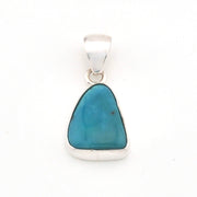 Turquoise pendant with silver setting on a white background