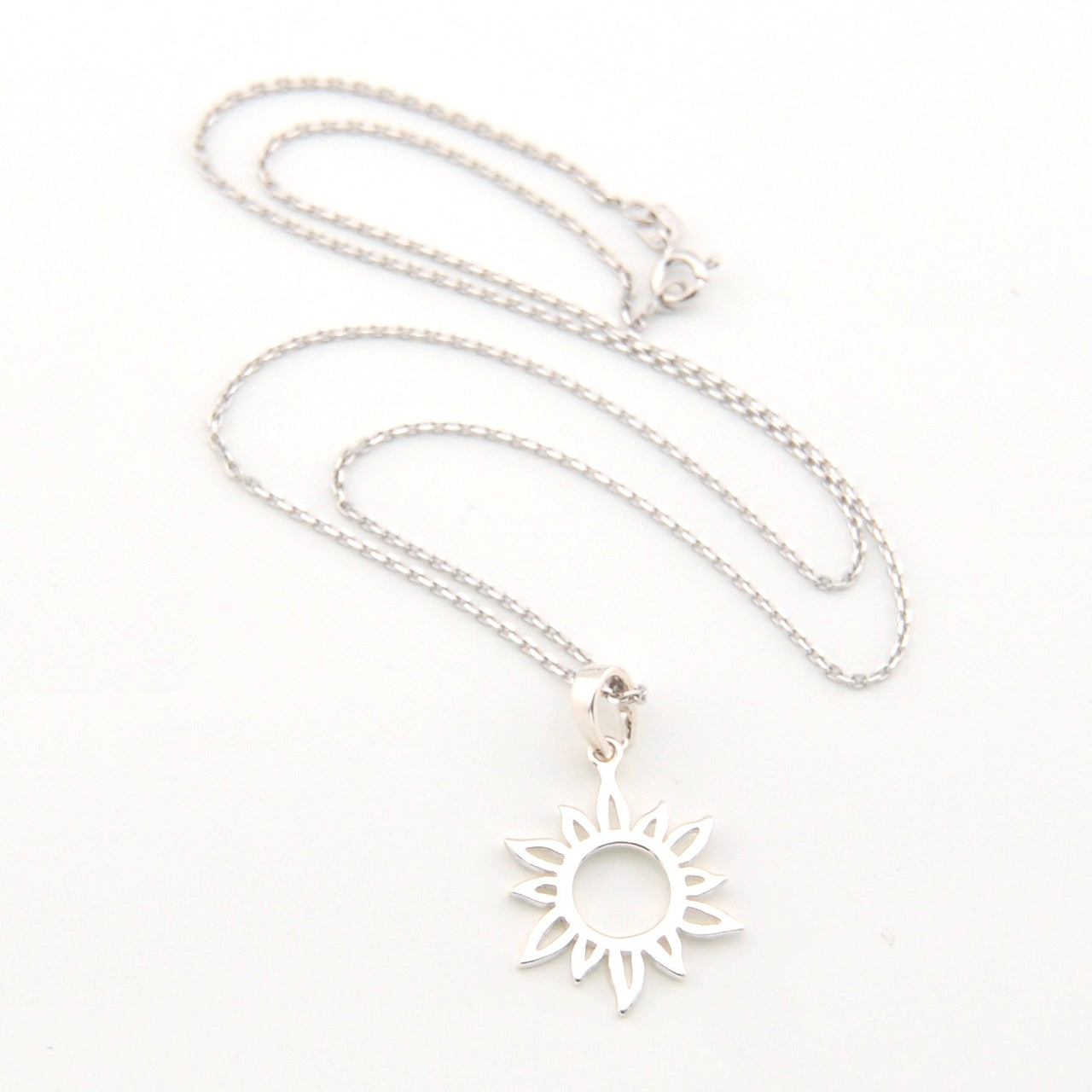 Silver necklace with a sun-shaped pendant on a white background