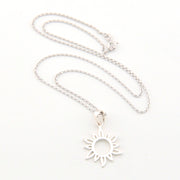Silver necklace with a sun-shaped pendant on a white background