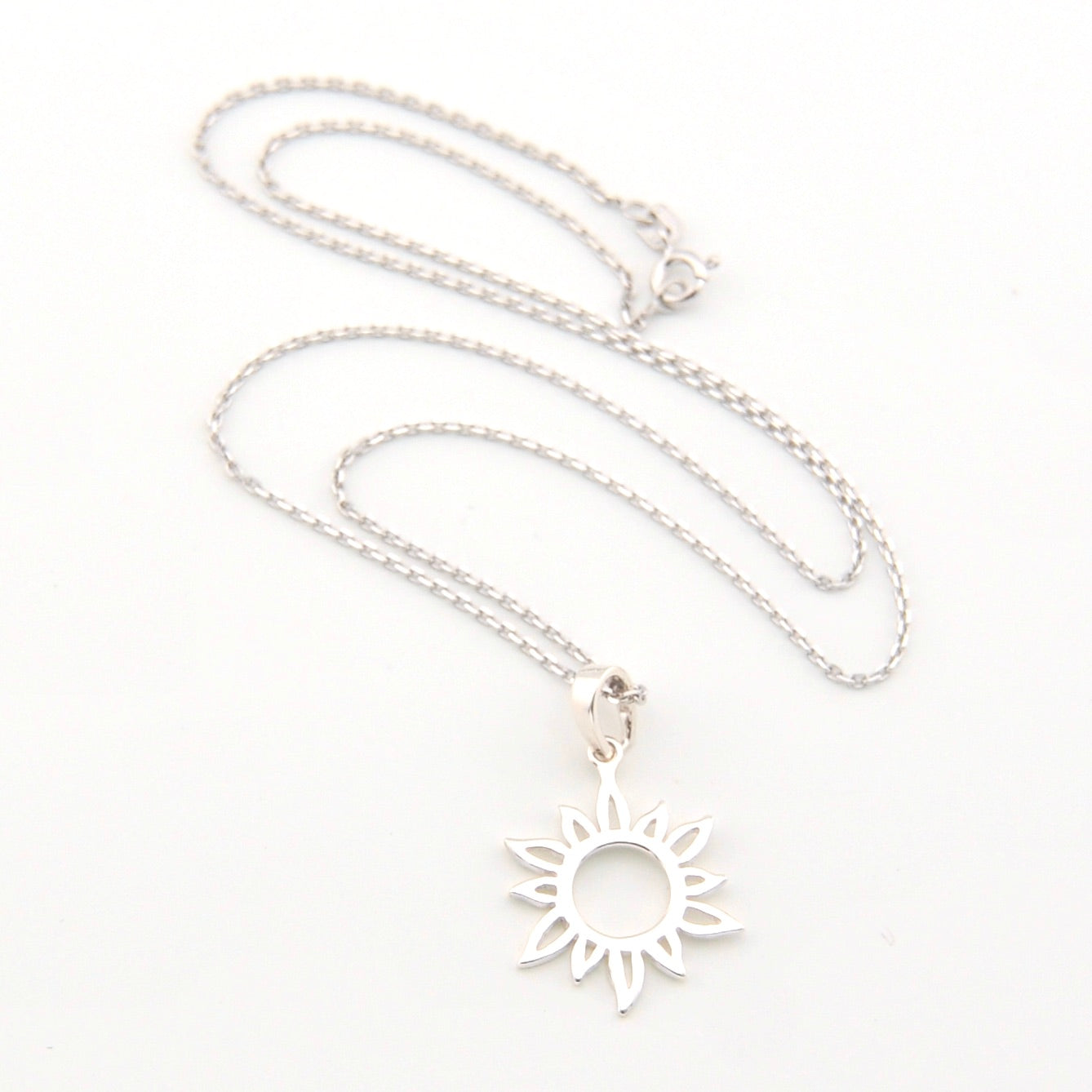 Silver necklace with a sun-shaped pendant on a white background