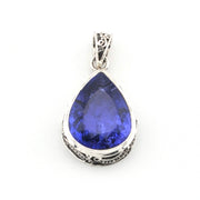 Teardrop-shaped blue gemstone pendant on a white background