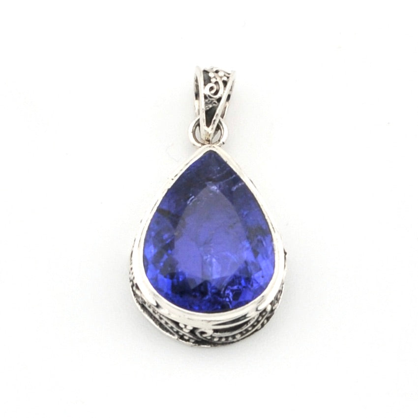 Teardrop-shaped blue gemstone pendant on a white background