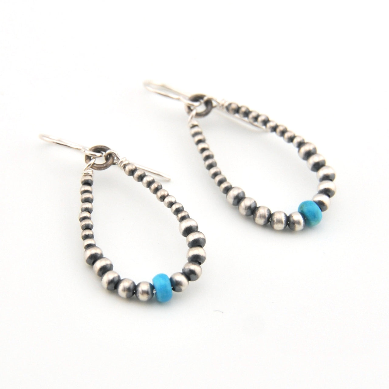 Pair of beaded earrings with blue accents on a white background