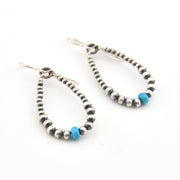 Pair of beaded earrings with blue accents on a white background