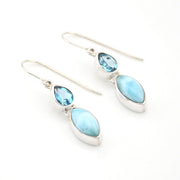 Silver earrings with blue gemstones on a white background