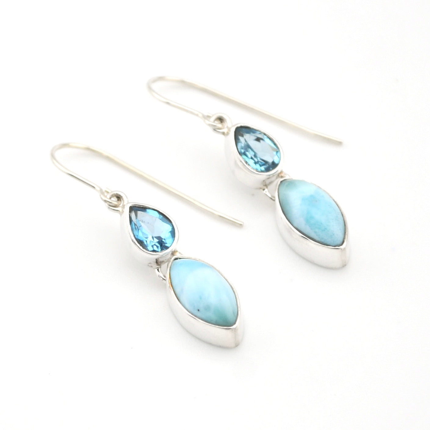 Silver earrings with blue gemstones on a white background
