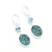 Pair of earrings with blue gemstones and turquoise-colored stones on a white background