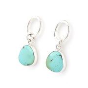 Turquoise teardrop earrings with silver hooks on a white background