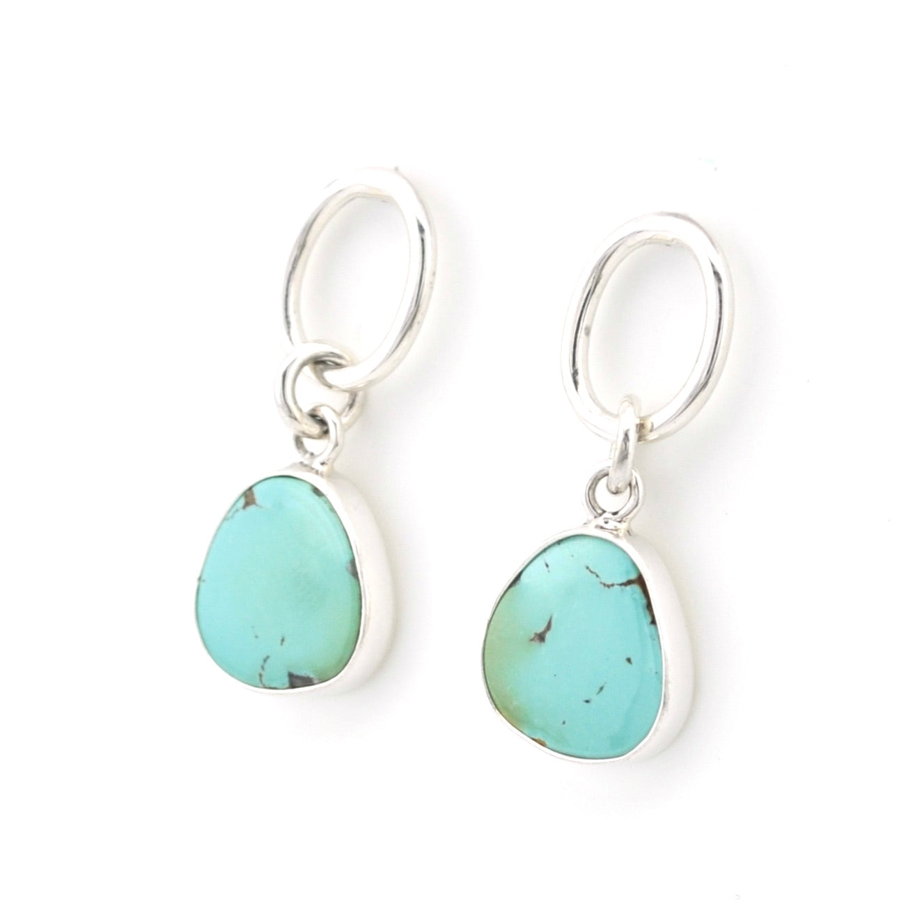 Turquoise teardrop earrings with silver hooks on a white background