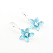 Pair of light blue flower earrings on a white background