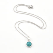 Silver necklace with a turquoise pendant on a white background