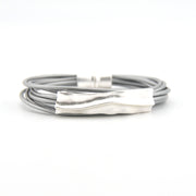 Silver bracelet with a textured clasp on a white background