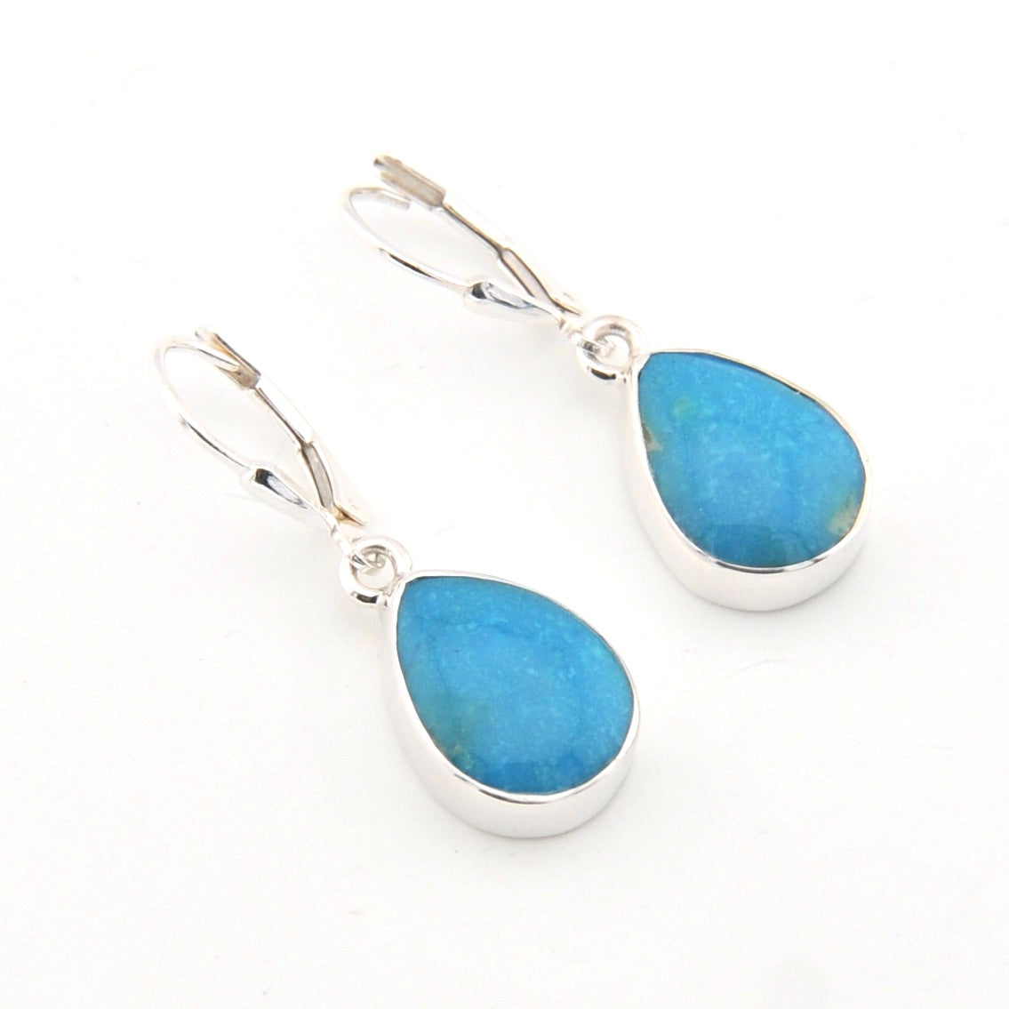 Teardrop-shaped blue earrings with silver settings on a white background
