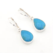 Teardrop-shaped blue earrings with silver settings on a white background