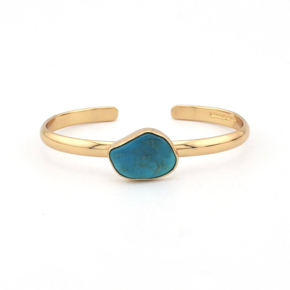 Gold bracelet with a blue stone on a white background