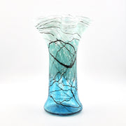Glass vase with blue and black pattern on a white background