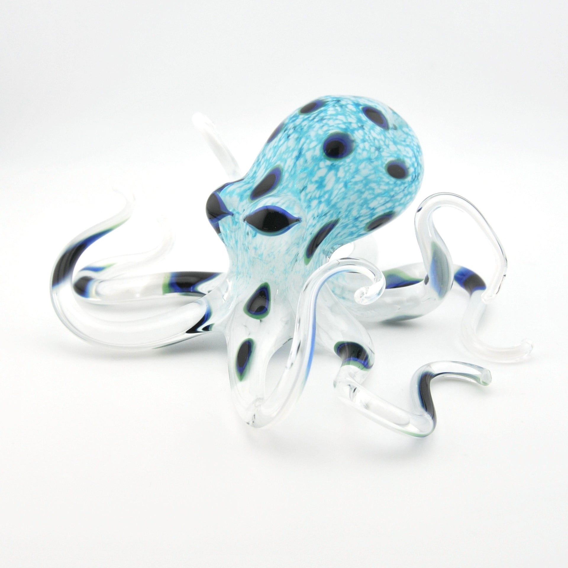 Glass octopus figurine with blue and black pattern on a white background