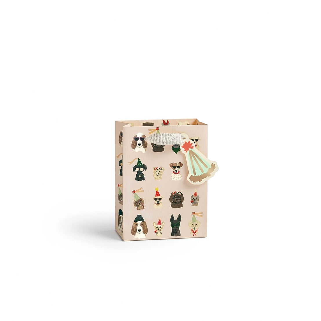 A beige paper gift bag decorated with illustrations of various dog breeds wearing winter clothing and a small Christmas tree ornament, shown on a clean white background.