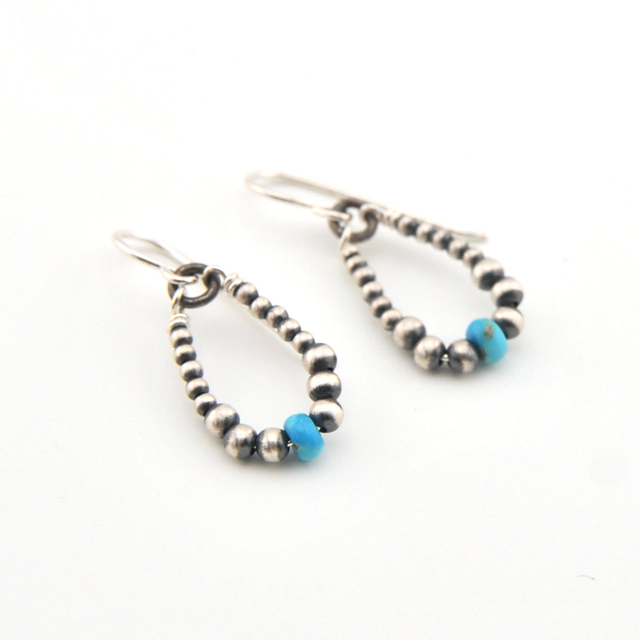 Pair of beaded earrings with blue accents on a white background