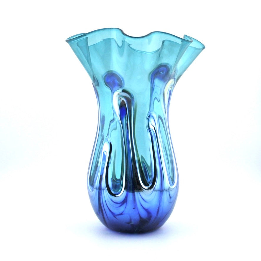 A decorative glass vase with a flared, ruffled rim and a bulbous base, featuring a swirled glass design that transitions from light aqua blue at the top to deep cobalt blue at the bottom, set against a plain white background.