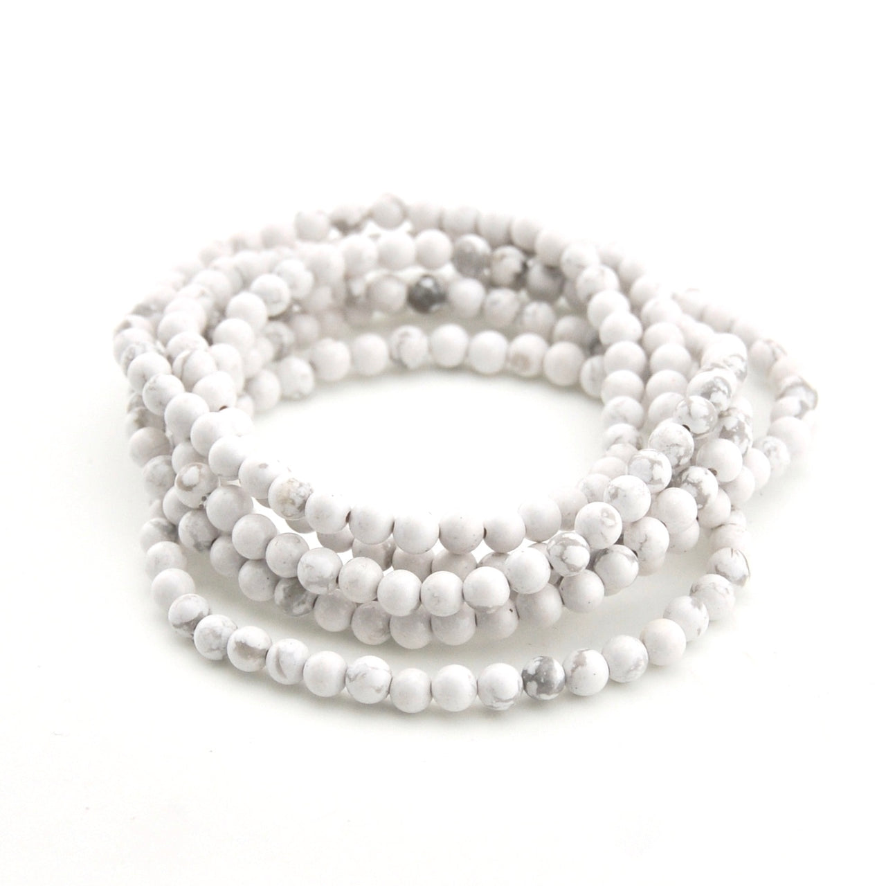 Stack of white beaded bracelets on a white background