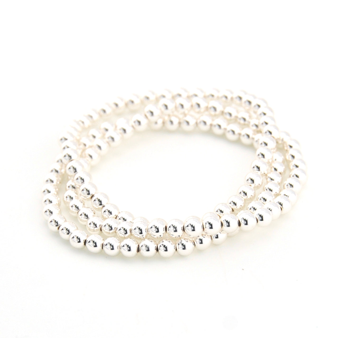 Stack of silver bracelets on a white background