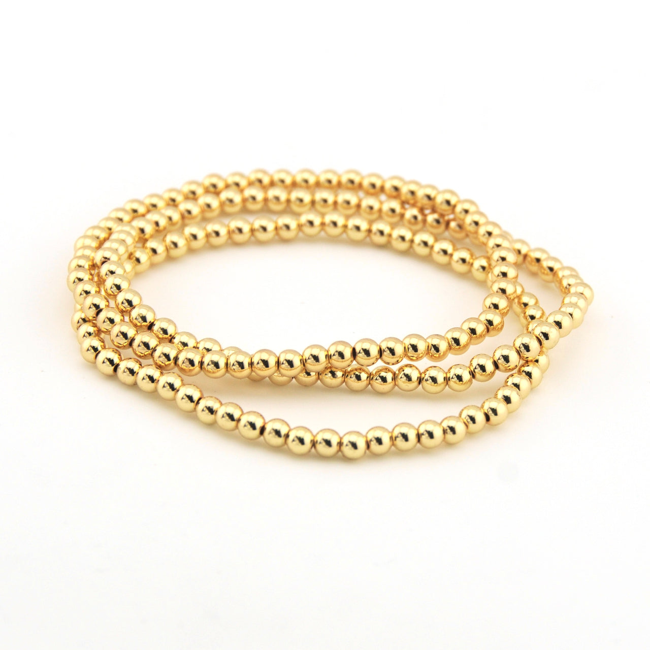Gold beaded bracelet on a white background
