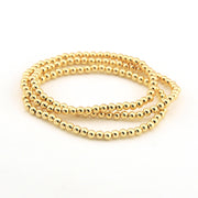 Gold beaded bracelet on a white background