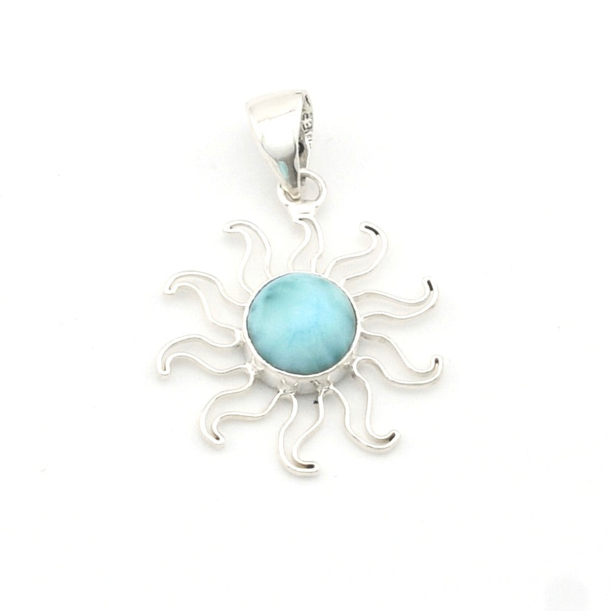 Silver sun-shaped pendant with a blue gemstone on a white background