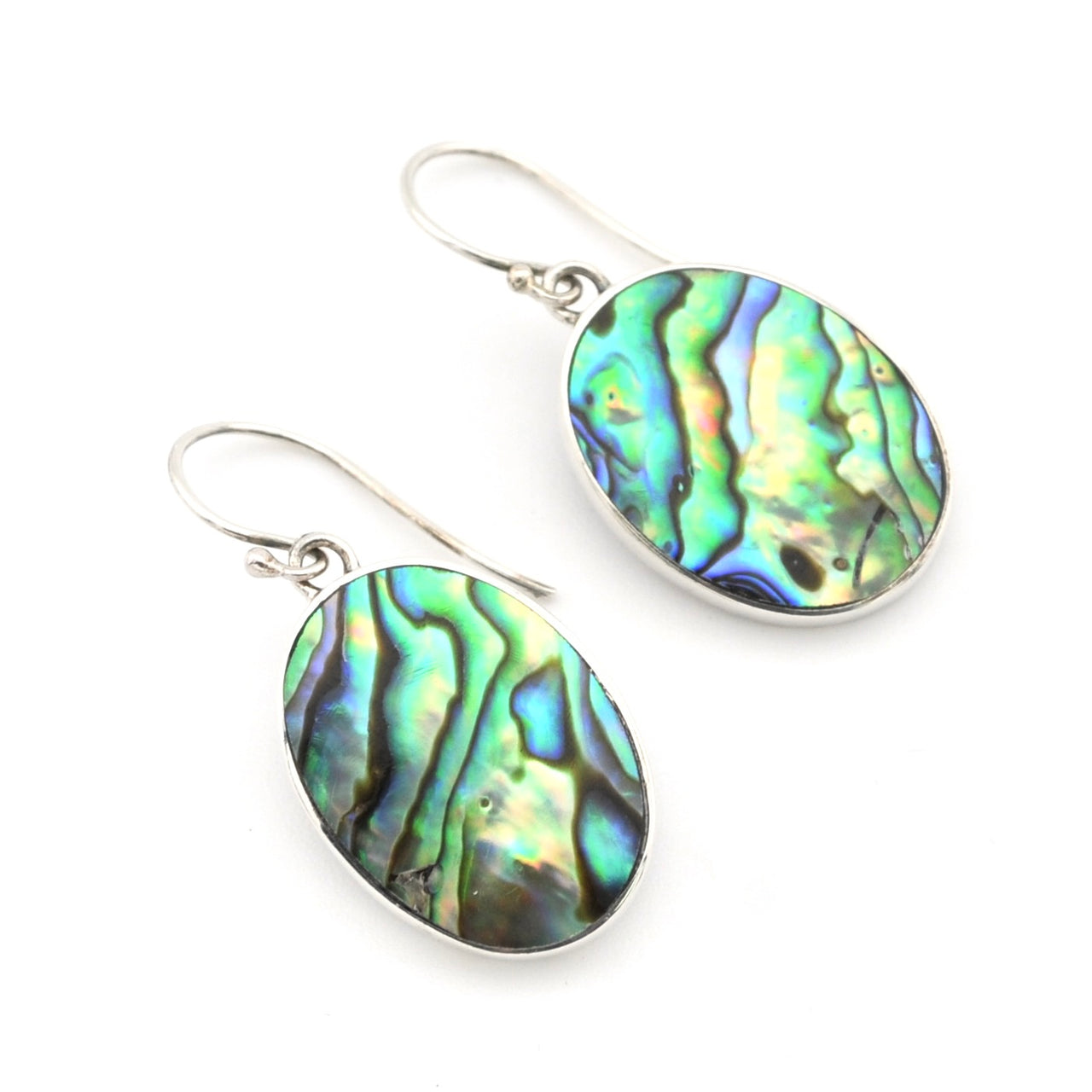 A pair of silver drop earrings featuring oval abalone shell pendants with a vibrant, iridescent green, blue, and gold pattern, set against a plain white background.