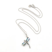 A silver dragonfly pendant necklace with iridescent blue-green inlay on the wings, displayed on a clean white background.