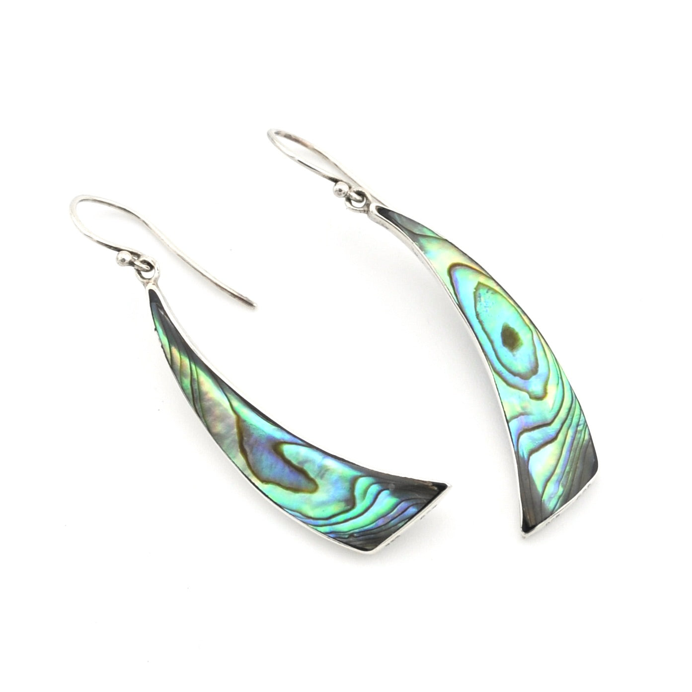 A pair of silver dangle earrings featuring curved, fan-shaped abalone shell inlays with iridescent green, blue, and purple patterns, shown on a plain white background.